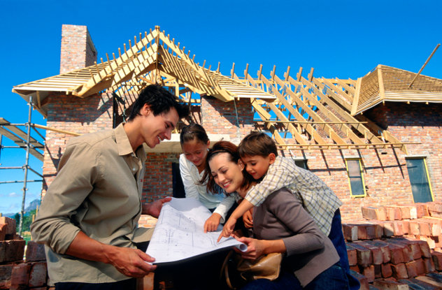 Family with blueprints at construction site