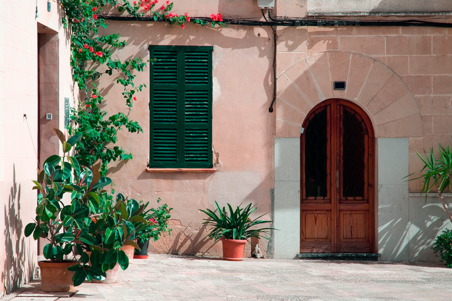 Portugiesisches Haus in Altrosa gestrichen mit Topfpflanzen vor der Tür